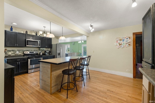 2890 W 400 N, Columbia City, IN 46725 - kitchen featuring appliances with stainless steel finishes, a kitchen bar, crown molding, light wood-style flooring, and a kitchen island