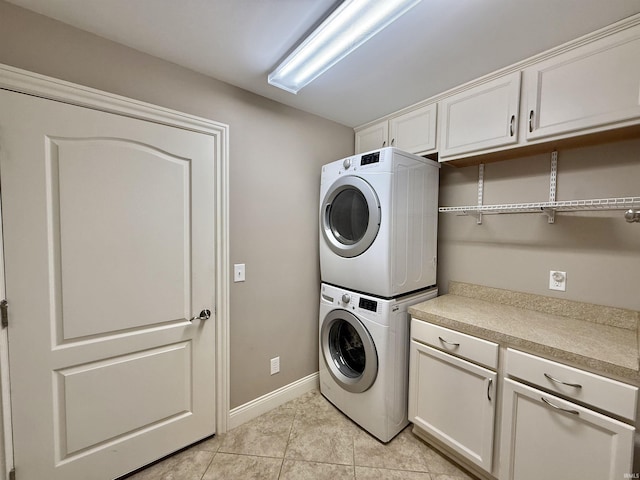9820 Arbor Lake Dr, Newburgh, IN 47630 - laundry area with stacked washer and clothes dryer, cabinet space, and light tile patterned floors