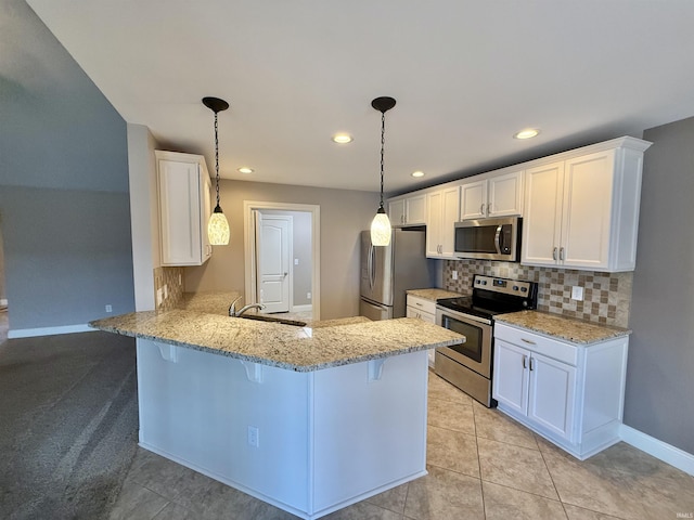 9820 Arbor Lake Dr, Newburgh, IN 47630 - kitchen with appliances with stainless steel finishes, a peninsula, a kitchen bar, white cabinetry, and tasteful backsplash