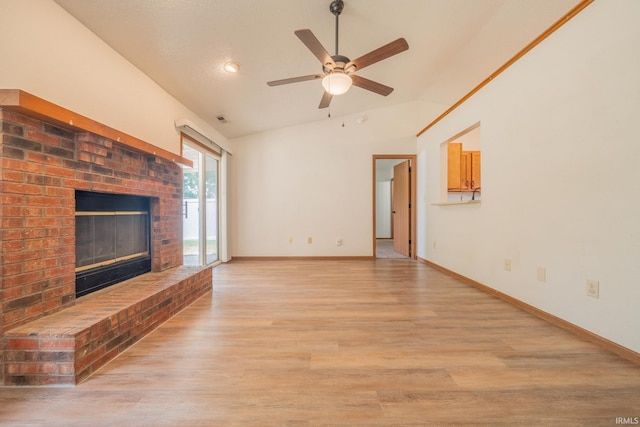 2645 Wynterpointe Ct, Kokomo, IN 46901 - unfurnished living room featuring vaulted ceiling, a brick fireplace, a ceiling fan, and light wood-style flooring