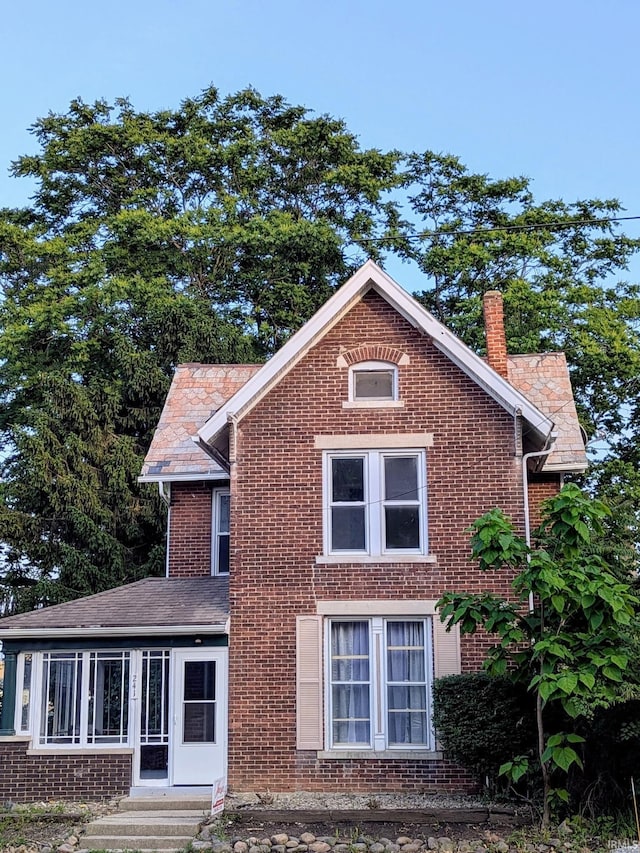 241 W Tipton St, Huntington, IN 46750 - view of side of home featuring a chimney, brick siding, and entry steps