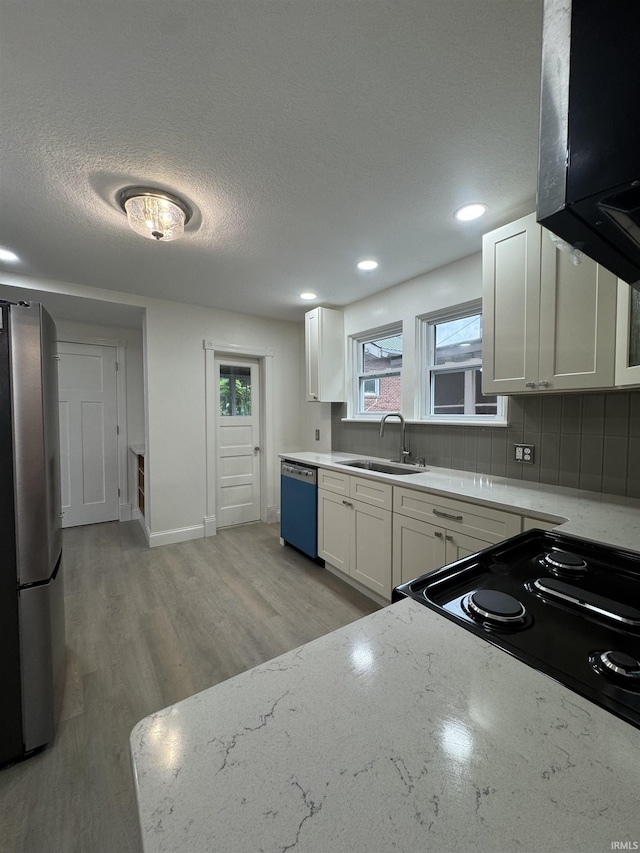 241 W Tipton St, Huntington, IN 46750 - kitchen with freestanding refrigerator, dishwasher, extractor fan, white cabinets, and decorative backsplash