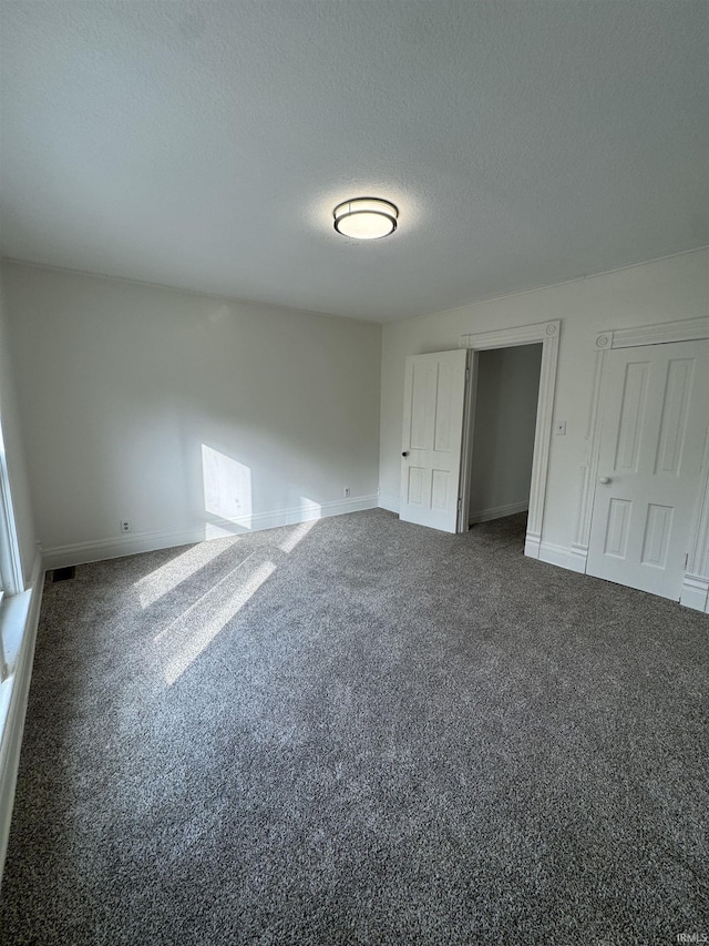 241 W Tipton St, Huntington, IN 46750 - unfurnished bedroom with a textured ceiling and carpet floors
