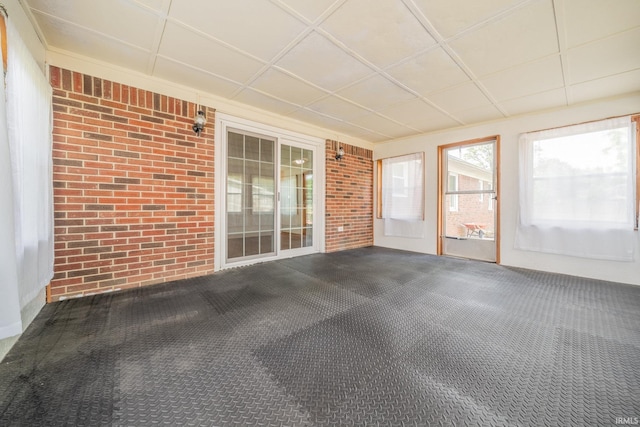 602 S Maple St, Galveston, IN 46932 - unfurnished sunroom with brick wall and carpet flooring