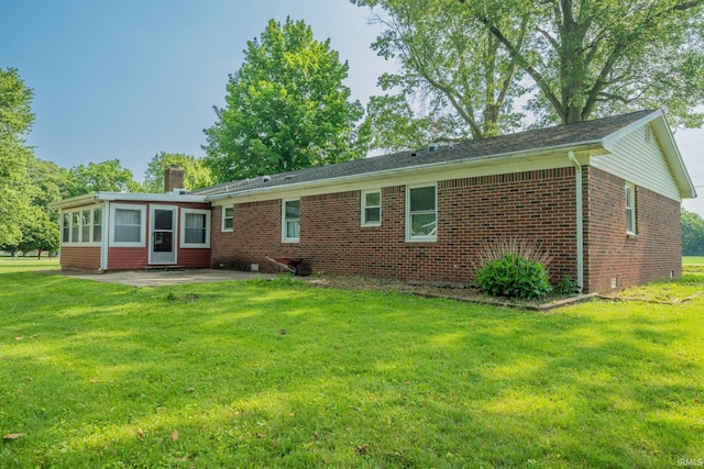602 S Maple St, Galveston, IN 46932 - back of house featuring brick siding, a patio area, a chimney, and a yard