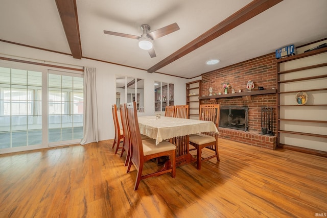 602 S Maple St, Galveston, IN 46932 - dining space featuring wood finished floors, a ceiling fan, a fireplace, and beamed ceiling