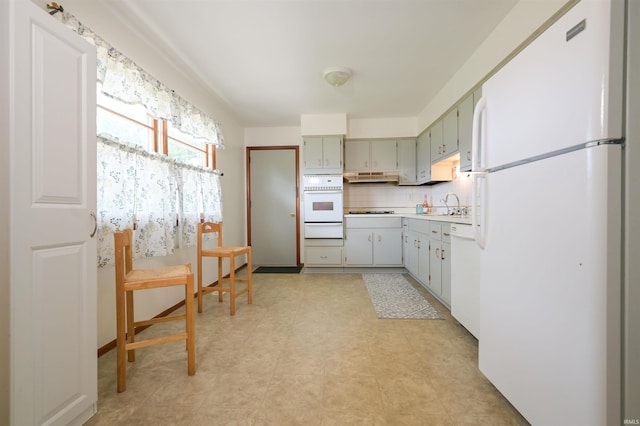 708 Carson Ct, Kokomo, IN 46902 - kitchen with white appliances, a warming drawer, under cabinet range hood, tasteful backsplash, and light countertops