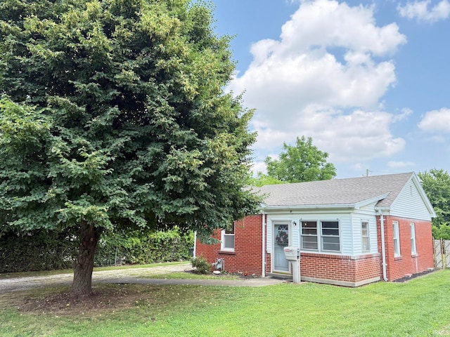 16 S Taft Ave, Evansville, IN 47714 - view of front facade featuring brick siding, a front lawn, and roof with shingles