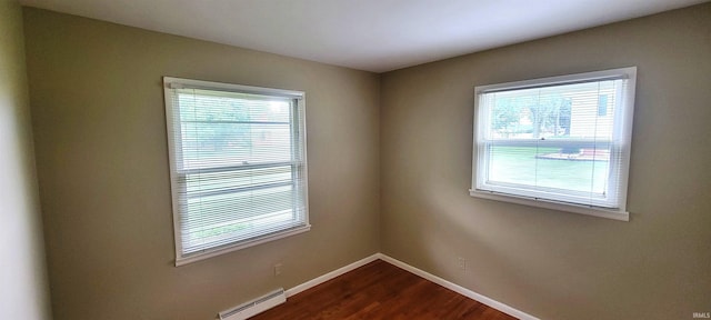 113 N Beechwood St, Warsaw, IN 46582 - empty room featuring baseboard heating, plenty of natural light, and dark wood-style floors