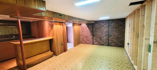 113 N Beechwood St, Warsaw, IN 46582 - finished basement with wooden walls, bar area, tile patterned floors, and brick wall