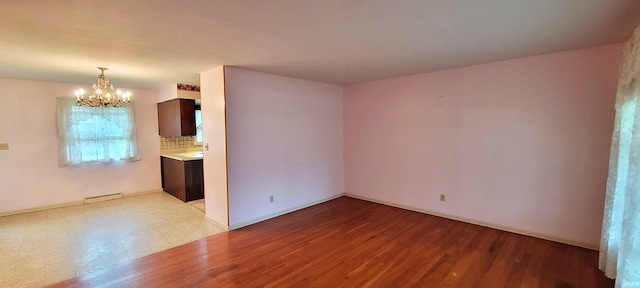 113 N Beechwood St, Warsaw, IN 46582 - unfurnished room featuring a chandelier and wood finished floors