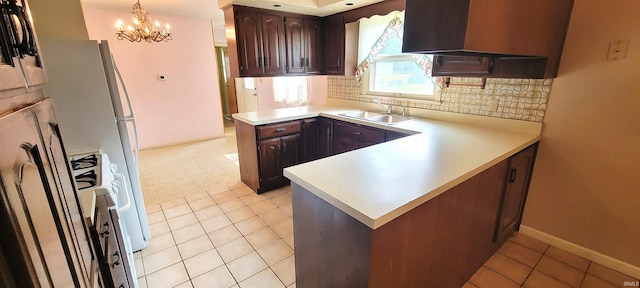 113 N Beechwood St, Warsaw, IN 46582 - kitchen featuring a peninsula, light countertops, a chandelier, tasteful backsplash, and dark brown cabinetry