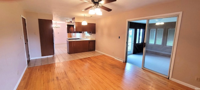 113 N Beechwood St, Warsaw, IN 46582 - kitchen with light wood finished floors, ceiling fan, light countertops, tasteful backsplash, and pendant lighting