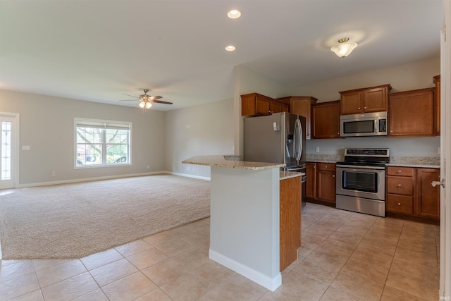7655 Briar Ct, Newburgh, IN 47630 - kitchen with appliances with stainless steel finishes, light colored carpet, brown cabinetry, light tile patterned floors, and light stone countertops
