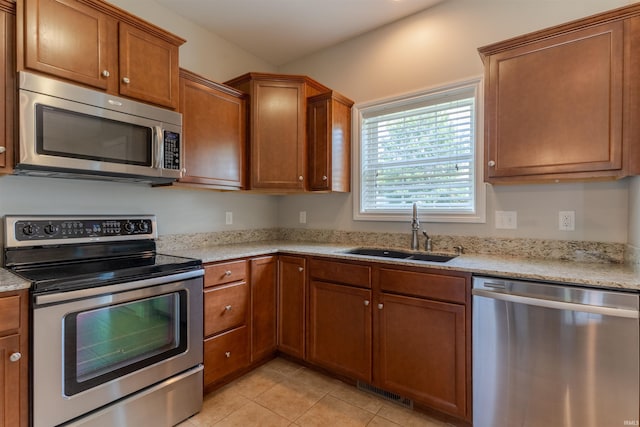 7655 Briar Ct, Newburgh, IN 47630 - kitchen featuring stainless steel appliances, brown cabinetry, light tile patterned flooring, and light stone counters