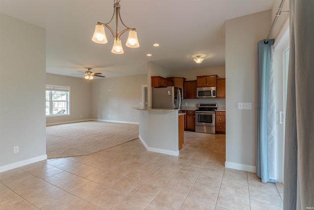 7655 Briar Ct, Newburgh, IN 47630 - kitchen with stainless steel appliances, open floor plan, light colored carpet, a chandelier, and a ceiling fan