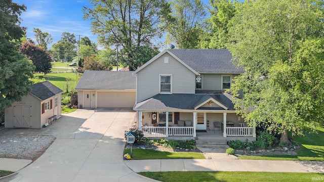 17612 State Road 37, Harlan, IN 46743 - view of front of property with a porch, driveway, an attached garage, a storage unit, and roof with shingles