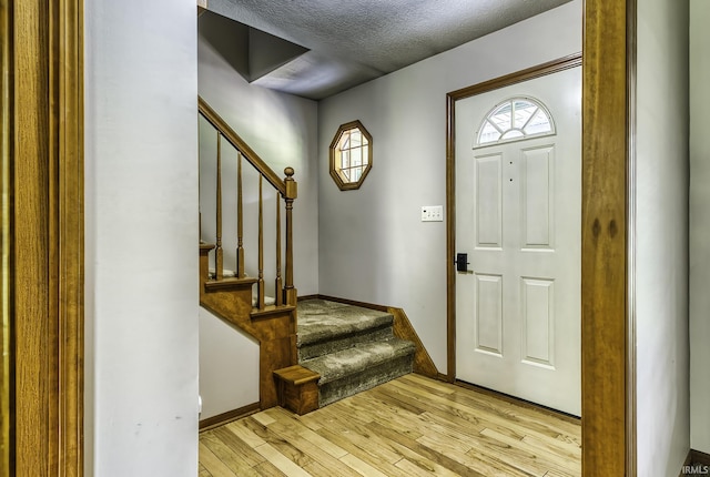 2560 E Maple Dr, Bluffton, IN 46714 - entryway with stairs, light wood-style floors, and a textured ceiling