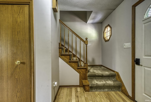 2560 E Maple Dr, Bluffton, IN 46714 - stairs featuring wood finished floors, a textured ceiling, and healthy amount of natural light