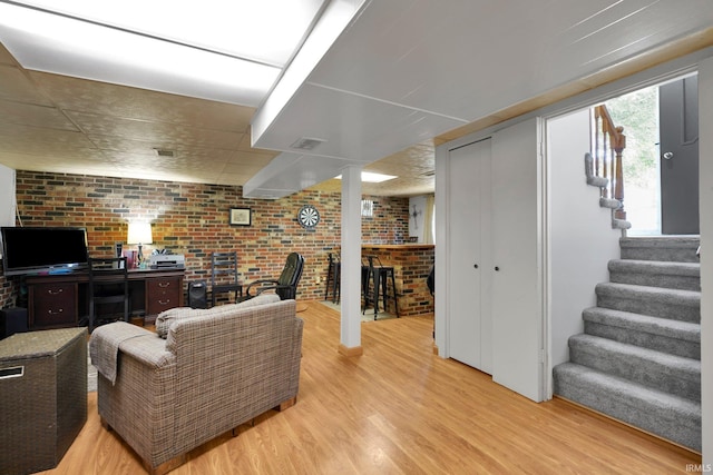 7244 Oaklawn Dr, Newburgh, IN 47630 - living area with brick wall, light wood-style flooring, stairs, and a desk
