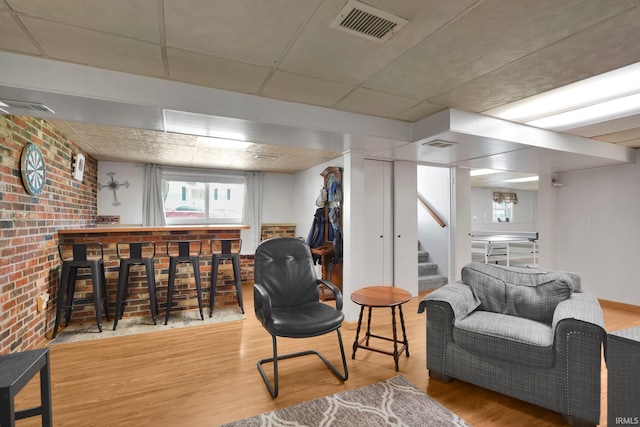 7244 Oaklawn Dr, Newburgh, IN 47630 - living area featuring a bar, wood finished floors, stairway, a paneled ceiling, and brick wall