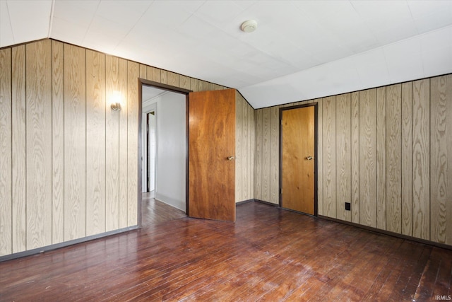 29351 Darden Rd, New Carlisle, IN 46552 - unfurnished room with wood-type flooring, wooden walls, vaulted ceiling, and a smoke detector