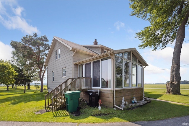 29351 Darden Rd, New Carlisle, IN 46552 - view of front facade with a front yard, a chimney, and a sunroom