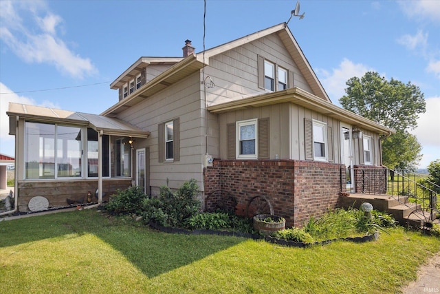 29351 Darden Rd, New Carlisle, IN 46552 - view of side of property featuring a lawn, brick siding, a chimney, a sunroom, and board and batten siding