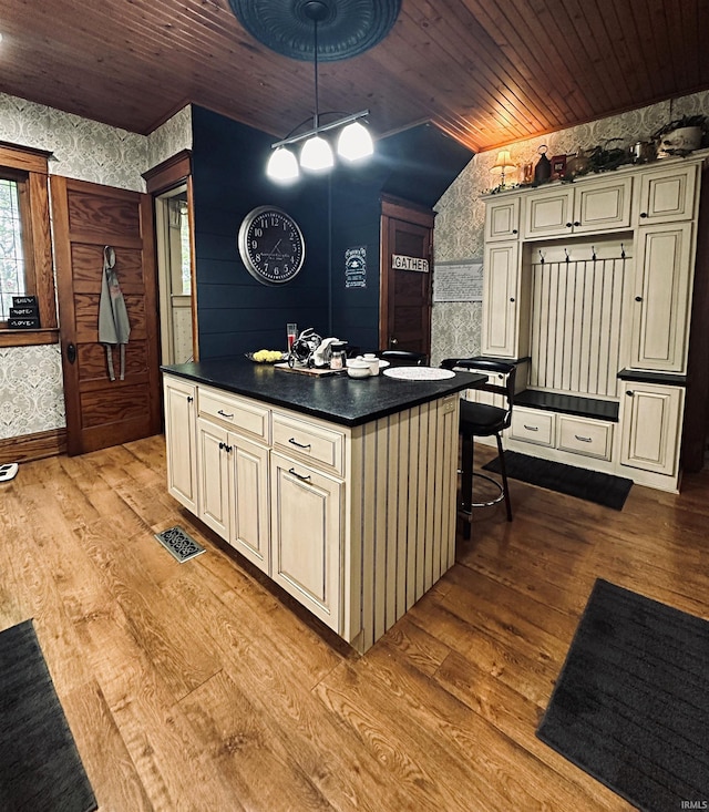 715 SE 2nd St, Washington, IN 47501 - kitchen featuring cream cabinetry, wallpapered walls, dark countertops, wooden ceiling, and light wood-style flooring