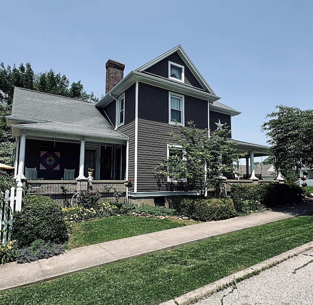 715 SE 2nd St, Washington, IN 47501 - view of front of property featuring a porch, a chimney, and a front yard