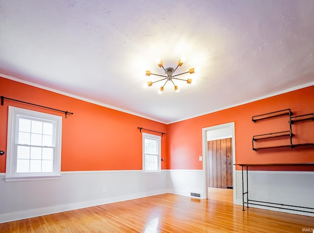 2801 W University Ave, Muncie, IN 47304 - spare room featuring wood finished floors, a chandelier, and ornamental molding