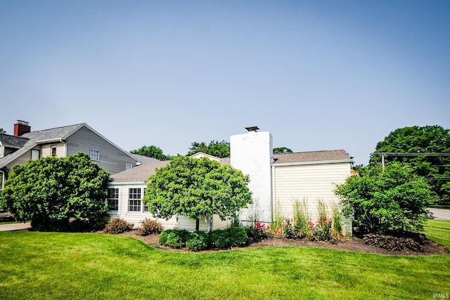 2801 W University Ave, Muncie, IN 47304 - view of property exterior featuring a chimney, a yard, and roof with shingles
