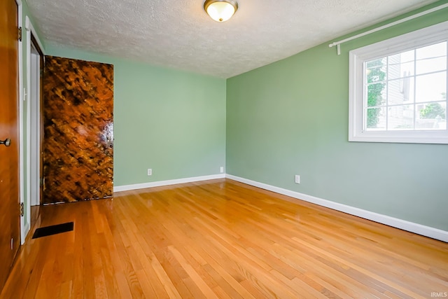 2801 W University Ave, Muncie, IN 47304 - spare room featuring a textured ceiling and hardwood / wood-style flooring