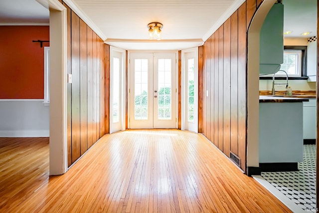 2801 W University Ave, Muncie, IN 47304 - foyer with light wood-style floors, french doors, ornamental molding, and arched walkways
