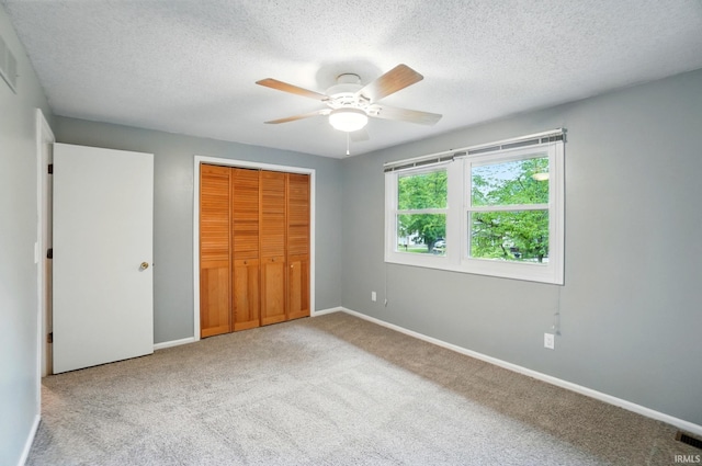 5820 Rosedale Dr, Fort Wayne, IN 46804 - unfurnished bedroom featuring carpet flooring, a textured ceiling, a closet, and a ceiling fan