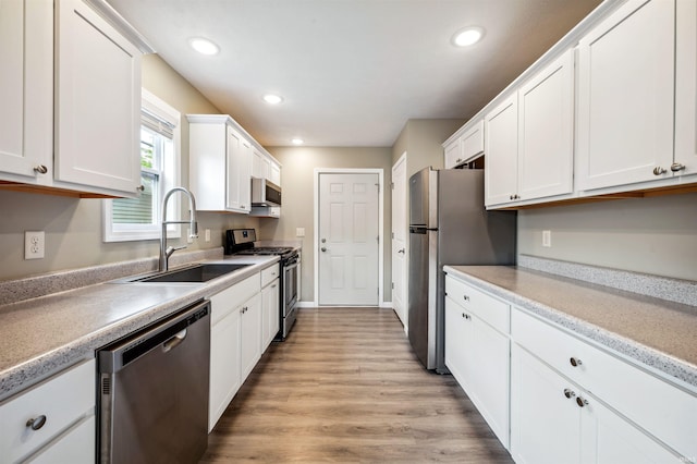1729 Carter Ct, Mishawaka, IN 46545 - kitchen featuring appliances with stainless steel finishes, white cabinets, light wood finished floors, recessed lighting, and light countertops