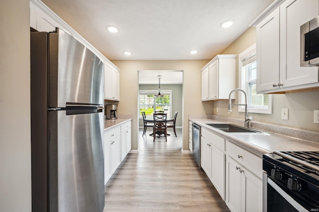 1729 Carter Ct, Mishawaka, IN 46545 - kitchen with appliances with stainless steel finishes, light countertops, white cabinets, light wood-type flooring, and recessed lighting