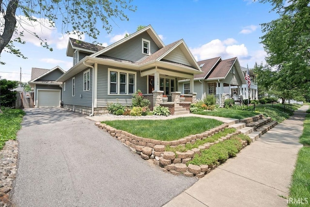 1106 W Maple St, Kokomo, IN 46901 - craftsman-style house with covered porch, asphalt driveway, a detached garage, and a front yard