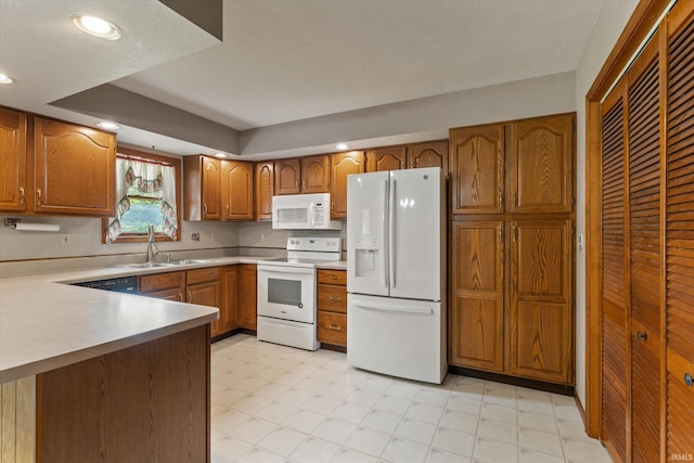 29230 Walerko Dr, Elkhart, IN 46514 - kitchen featuring white appliances, brown cabinetry, a peninsula, light countertops, and recessed lighting