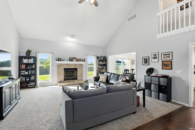 10412 Kentfield Pl, Fort Wayne, IN 46818 - living room featuring high vaulted ceiling, dark wood-style flooring, ceiling fan, a fireplace with raised hearth, and healthy amount of natural light