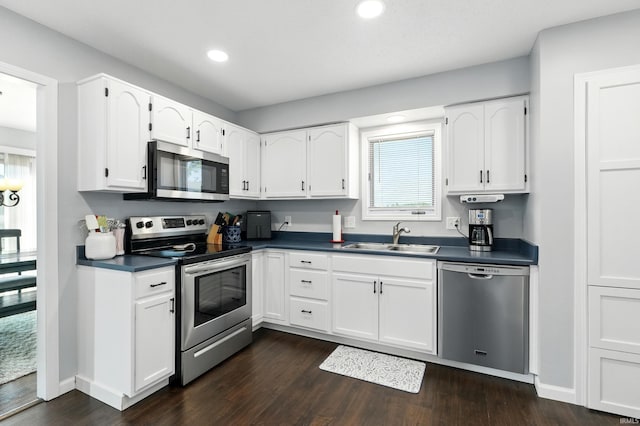 10412 Kentfield Pl, Fort Wayne, IN 46818 - kitchen featuring appliances with stainless steel finishes, dark countertops, dark wood-type flooring, white cabinets, and recessed lighting