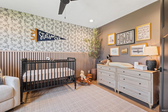 11306 Fishers Pond, Middlebury, IN 46540 - bedroom featuring wallpapered walls, a crib, wood finished floors, and recessed lighting