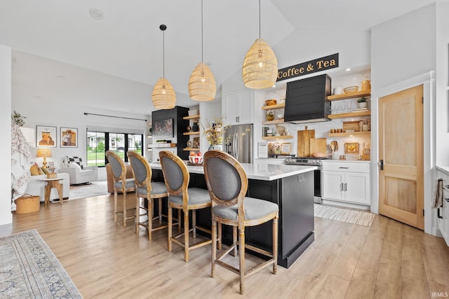 11306 Fishers Pond, Middlebury, IN 46540 - kitchen with open shelves, appliances with stainless steel finishes, exhaust hood, a kitchen island, and light countertops