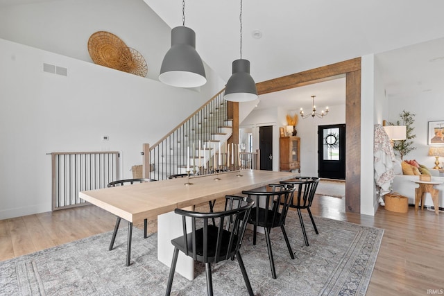 11306 Fishers Pond, Middlebury, IN 46540 - dining room featuring high vaulted ceiling, stairs, wood finished floors, and a chandelier