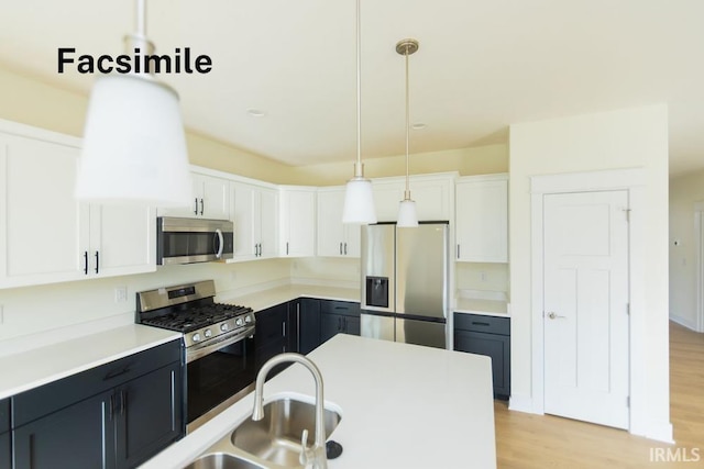 4651 S Quinn Dr, Bloomington, IN 47403 - kitchen featuring stainless steel appliances, white cabinets, light wood-style flooring, decorative light fixtures, and light countertops