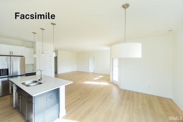 4651 S Quinn Dr, Bloomington, IN 47403 - kitchen with appliances with stainless steel finishes, light wood finished floors, open floor plan, light countertops, and a center island with sink