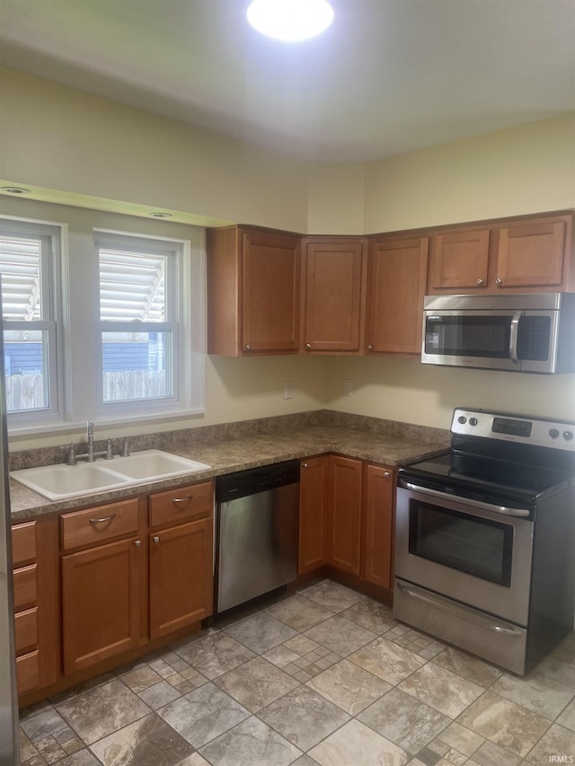 1715 Everett St, Lafayette, IN 47905 - kitchen featuring appliances with stainless steel finishes, brown cabinets, dark countertops, and light stone finish floors