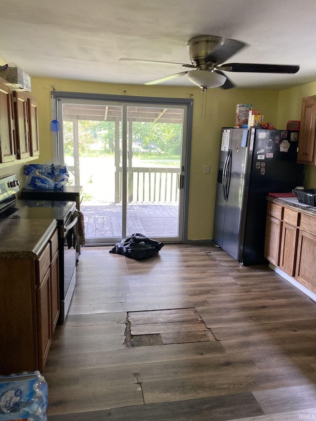 1409 W King St, Garrett, IN 46738 - kitchen with stainless steel appliances, a ceiling fan, dark countertops, and dark wood-style floors