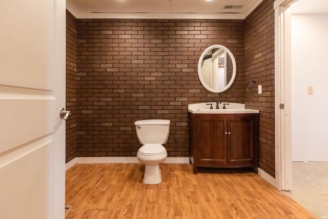 7486 S Ketcham Rd, Bloomington, IN 47403 - bathroom with brick wall, vanity, and wood finished floors