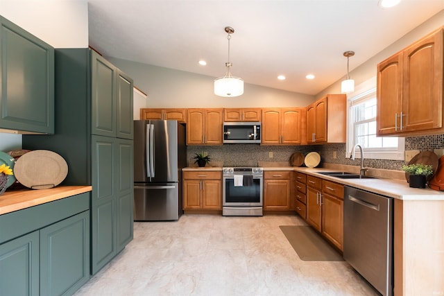 7486 S Ketcham Rd, Bloomington, IN 47403 - kitchen featuring appliances with stainless steel finishes, backsplash, vaulted ceiling, hanging light fixtures, and light countertops